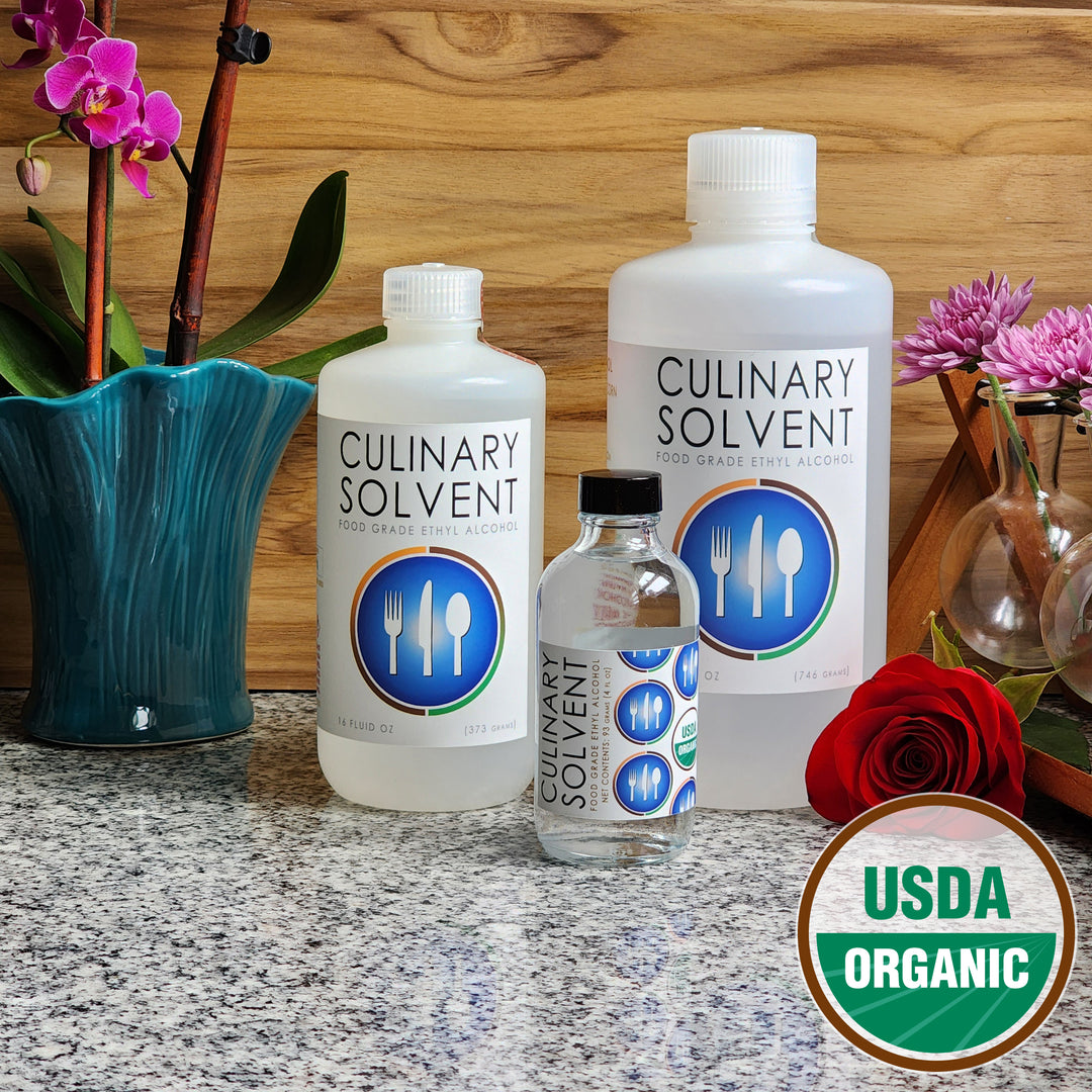 Pure Organic Perfumers Alcohol pint, quart, and glass bottles by Culinary Solvent food grade ethanol with orchids, roses, and fresh flowers teak wood background