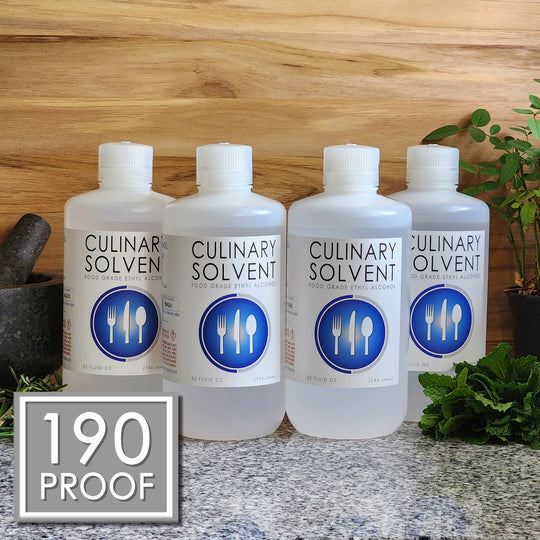 Pure 190 Proof Food Grade Ethanol gallon by Culinary Solvent with rosemary, mint, and fresh herbs for tincture on teak wood background