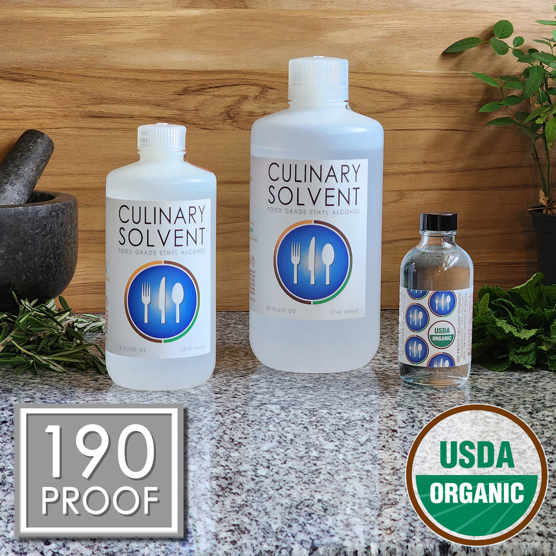 Pure USDA Organic Food Grade Ethanol by Culinary Solvent with rosemary, mint, and fresh herbs for tincture on teak wood background