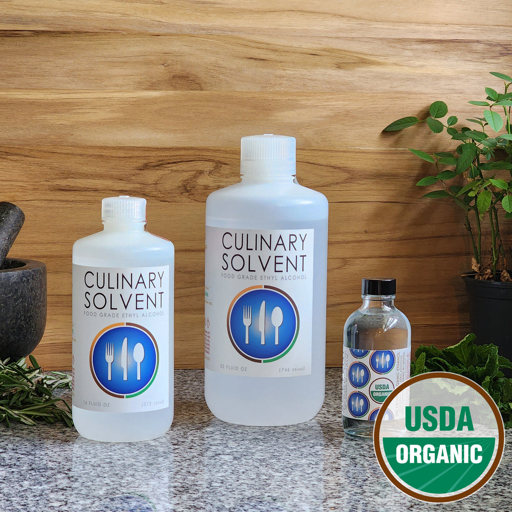 Pure USDA Organic Food Grade Ethanol by Culinary Solvent with rosemary, mint, and fresh herbs for tincture on teak wood background