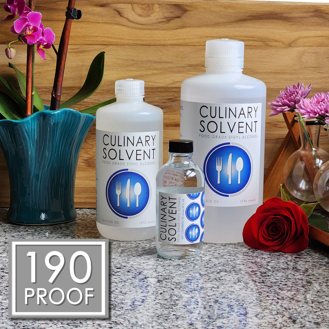 Pure Perfumers Alcohol pint, quart, and glass bottles by Culinary Solvent food grade ethanol with orchids, roses, and fresh flowers teak wood background