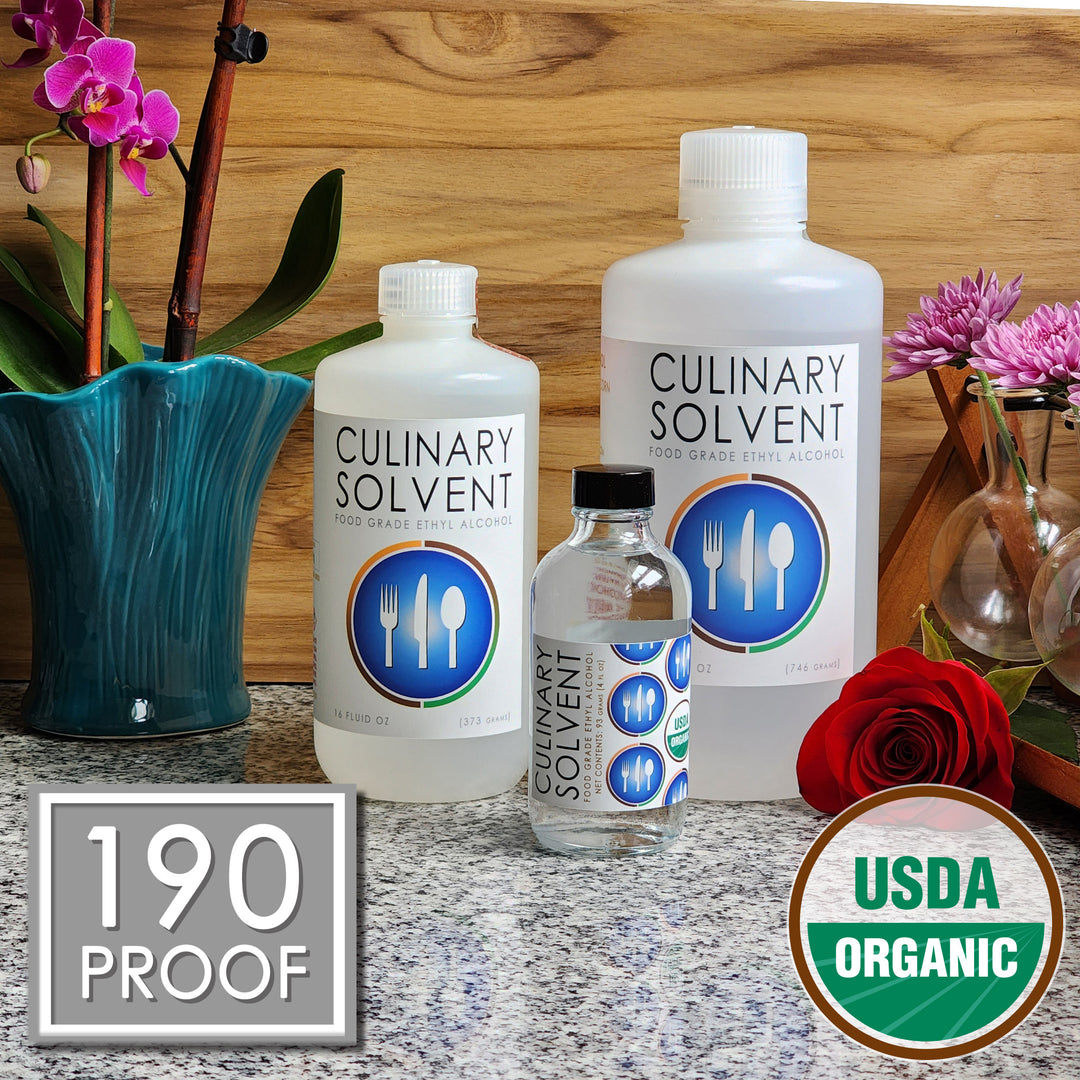 Pure Organic Perfumers Alcohol pint, quart, and glass bottles by Culinary Solvent food grade ethanol with orchids, roses, and fresh flowers teak wood background