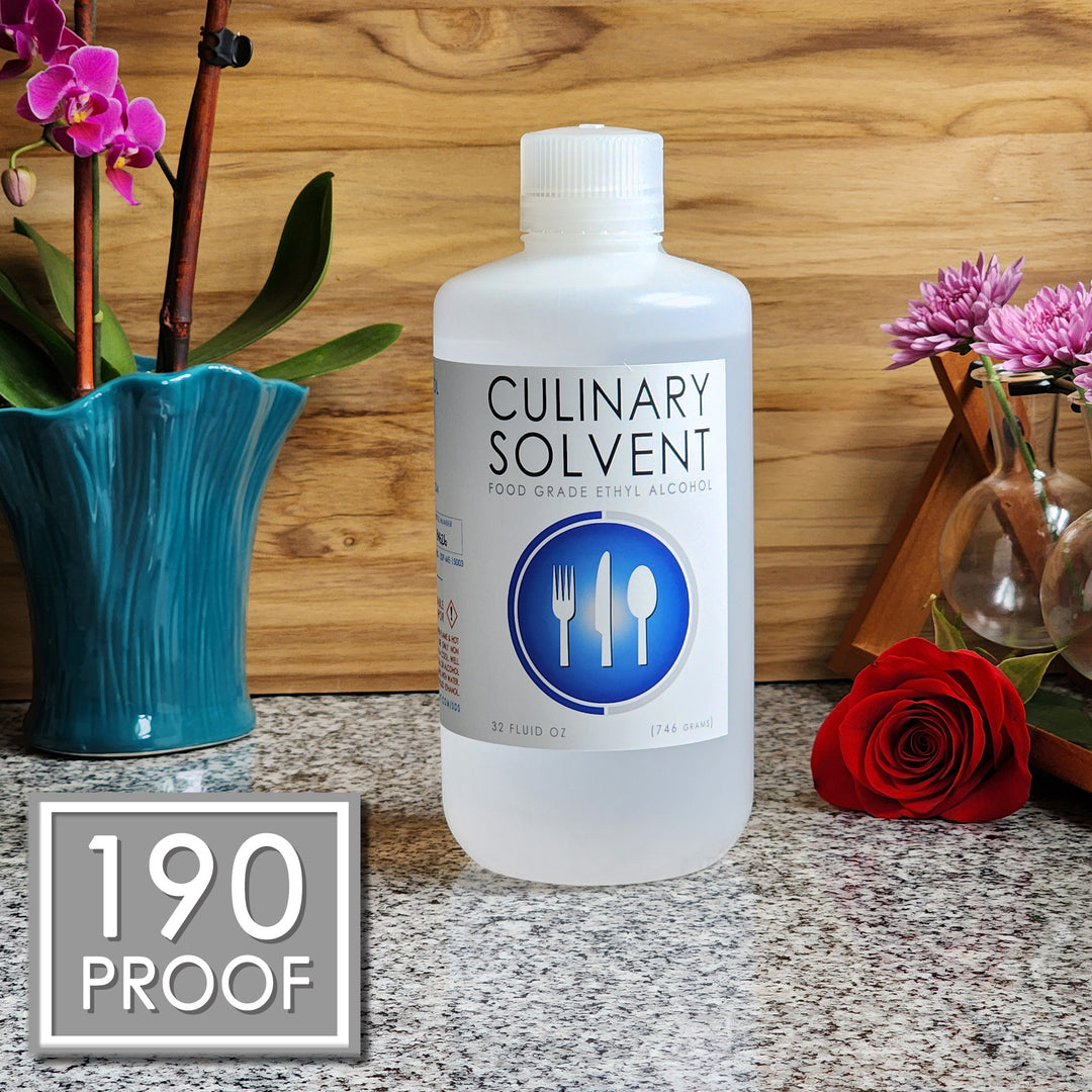 Pure Perfumers Alcohol quart bottle by Culinary Solvent food grade ethanol with orchids, roses, and fresh flowers teak wood background