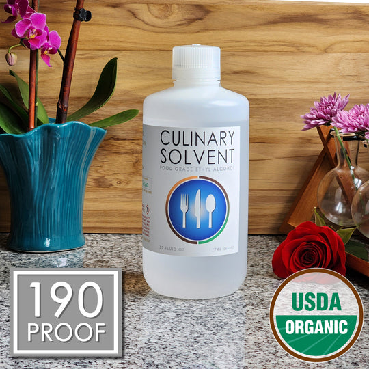 Pure Organic Perfumers Alcohol quart bottle by Culinary Solvent food grade ethanol with orchids, roses, and fresh flowers teak wood background
